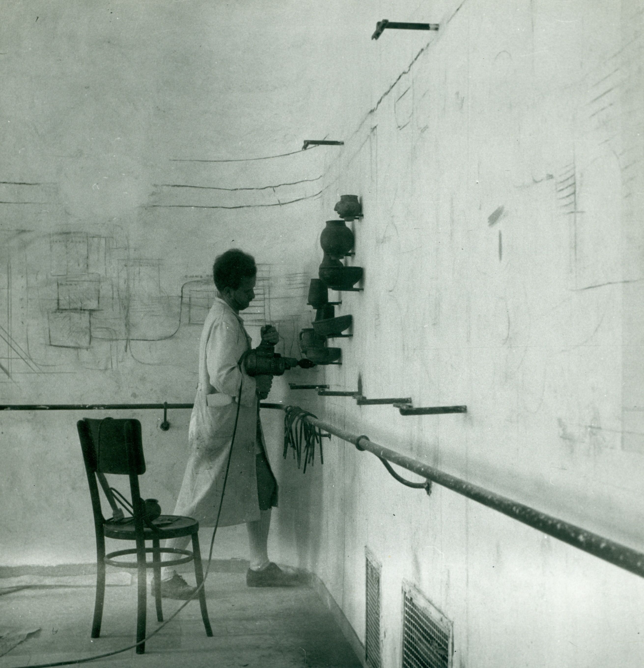 Wagner Nándor terra sigillatákat erősít a falra. (István Király Múzeum, 1950)